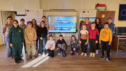 Grup de elevi în CDI, cu ecran și bannere UE