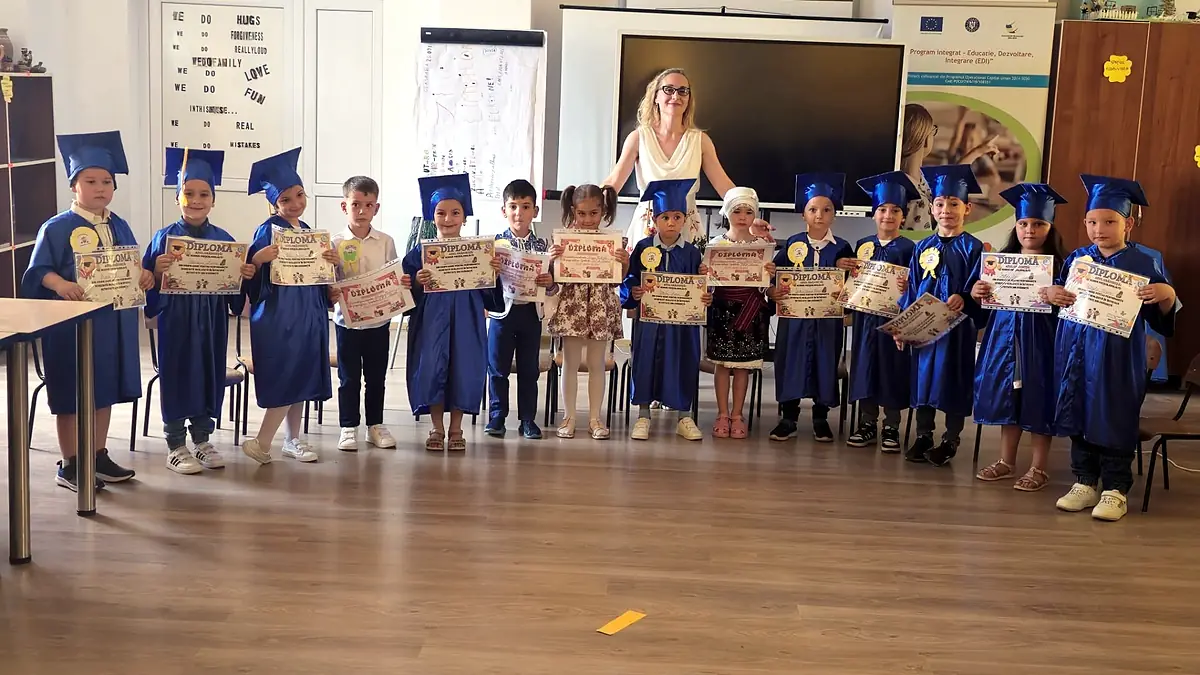 „La revedere, grădiniță!” 2024, preșcolari cu toga și tocă albastră și educatoarea