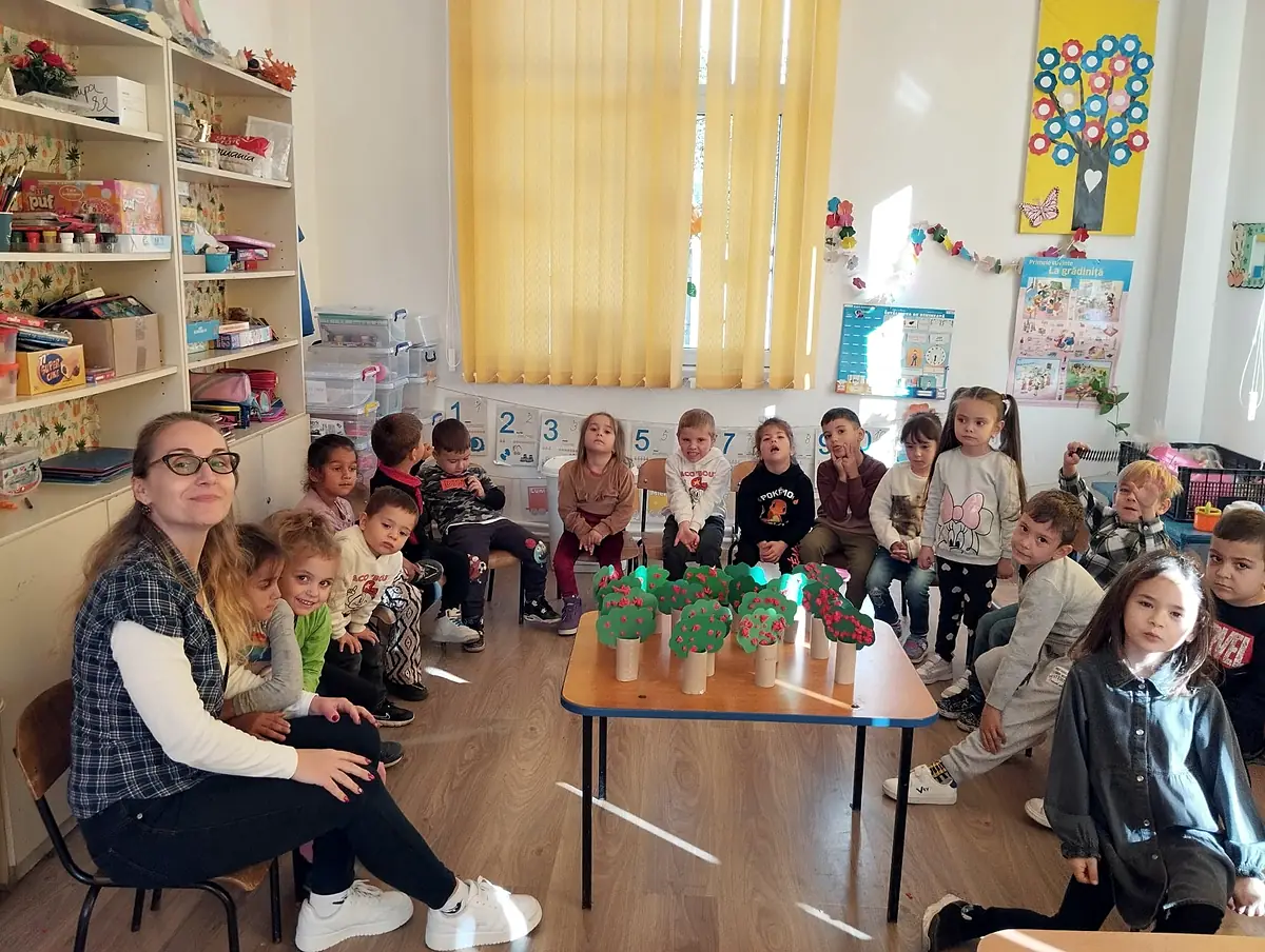 Sala de grupă a grădiniței, preșcolari în cerc cu plante